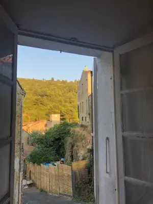 an open window with a view of a building at Chez Tatie Ménie in Fraissé-des-Corbières