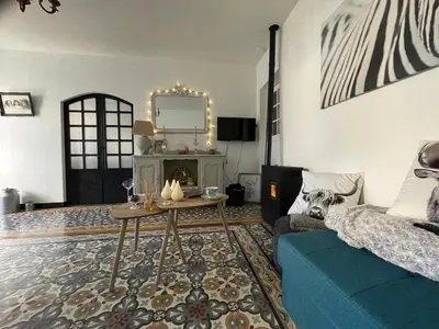 a living room with a blue couch and a table at Chez Tatie Ménie in Fraissé-des-Corbières