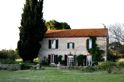 a large stone house with a red roof at Maison Saraphina in Cruzy