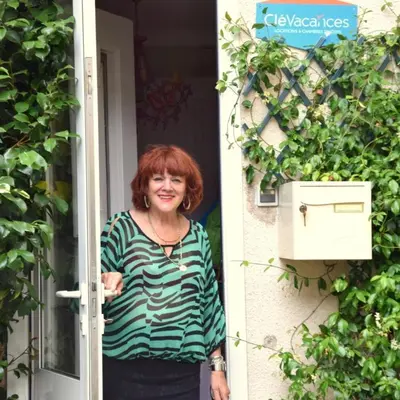 a woman standing at the door of a house at Chambre d'hôtes chez Claude Bardou in Lacrouzette