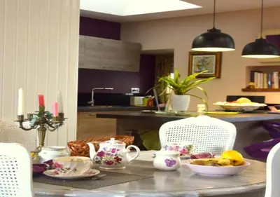 a table with a bowl of fruit on it in a kitchen at Chambre d'hôtes chez Claude Bardou in Lacrouzette