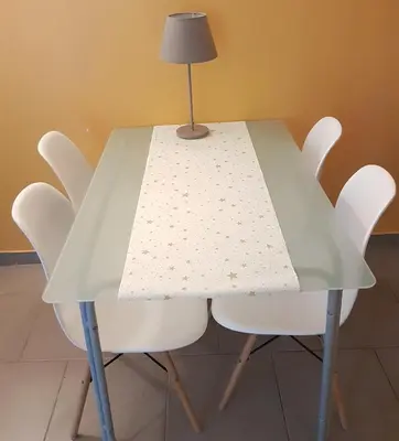 a table with white chairs and a lamp on top at Maison vue Cité 2 in Carcassonne