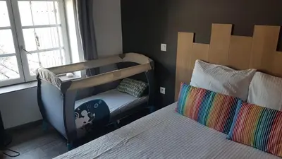 a bedroom with a bed and a chair next to a window at Maison vue Cité 2 in Carcassonne