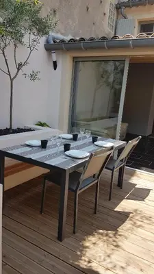 a table with chairs and wine glasses on a patio at Maison vue Cité 2 in Carcassonne