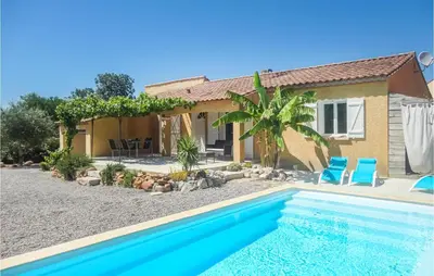 a villa with a swimming pool in front of a house at Cozy Home In Salles D'aude With Wifi in Salles-d'Aude