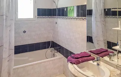 a bathroom with a tub and a sink with purple towels at Cozy Home In Salles D'aude With Wifi in Salles-d'Aude