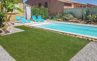 a swimming pool with chairs next to a house at Cozy Home In Salles D'aude With Wifi in Salles-d'Aude