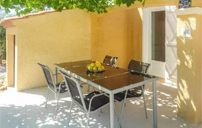 a table with chairs and a bowl of fruit on it at Cozy Home In Salles D'aude With Wifi in Salles-d'Aude