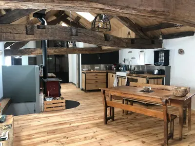a kitchen with wooden floors and a wooden table at Gîte Terra Bosca in Cambounès