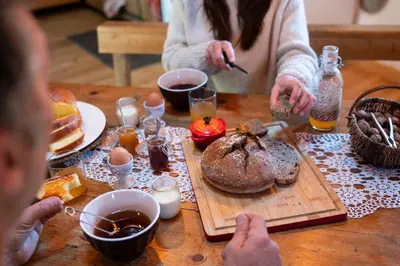 a group of people sitting at a table with food at Gîte Terra Bosca in Cambounès