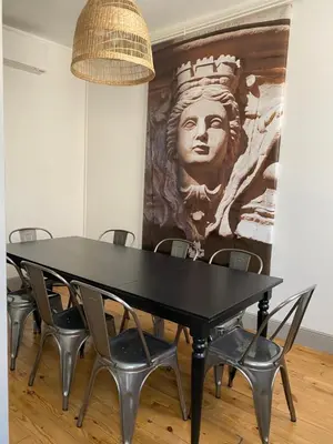 a black table with chairs in a room with a painting at Maison rue Trivalle in Carcassonne