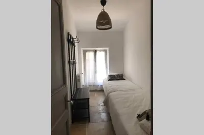 a small bedroom with a bed and a window at Maison rue Trivalle in Carcassonne