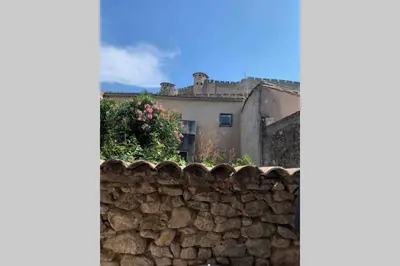 a stone wall with a building in the background at Maison rue Trivalle in Carcassonne