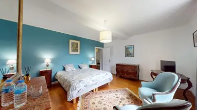a bedroom with a bed and a blue wall at Les Terrisses - Chambres d'hôtes avec piscine in Saint-Félix-Lauragais