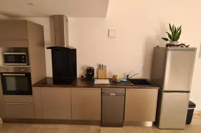a kitchen with a refrigerator and a counter top at Ruby - Gîte 2 chambres dans vieux prieuré près de Carcassonne in Sainte-Eulalie
