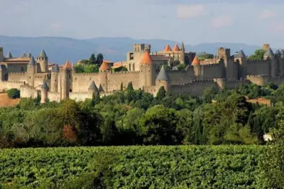 a large castle sitting on top of a hill at Ruby - Gîte 2 chambres dans vieux prieuré près de Carcassonne in Sainte-Eulalie