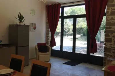 a living room with a large window with red curtains at Ruby - Gîte 2 chambres dans vieux prieuré près de Carcassonne in Sainte-Eulalie