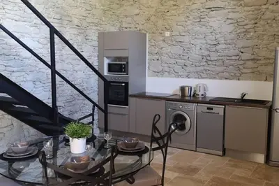 a kitchen with a table and a stove and a microwave at Diamond - Gîte dans vieux prieuré près de Carcassonne in Sainte-Eulalie