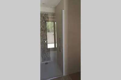 a shower with a glass door in a bathroom at Diamond - Gîte dans vieux prieuré près de Carcassonne in Sainte-Eulalie