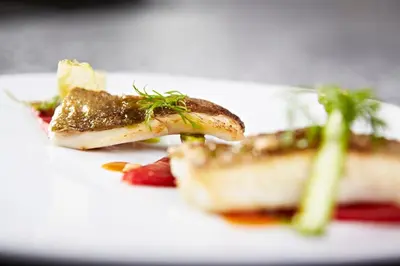 a white plate with a piece of food on it at Hôtel Mets et Plaisirs in Mazamet