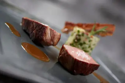 a plate of food with meat and other foods at Hôtel Mets et Plaisirs in Mazamet