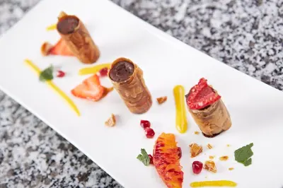 a white plate with some food on a table at Hôtel Mets et Plaisirs in Mazamet
