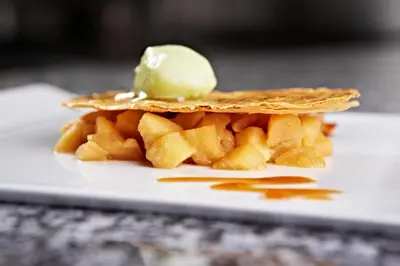 a plate with a piece of food with a ice cream on it at Hôtel Mets et Plaisirs in Mazamet