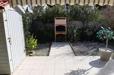 a backyard with a fence and a chair in a yard at Pavillon Grazel GRUISSAN in Gruissan