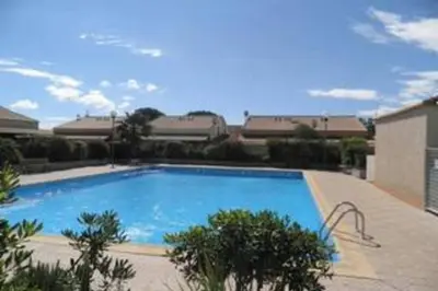 a large blue swimming pool in front of a building at Pavillon Grazel GRUISSAN in Gruissan
