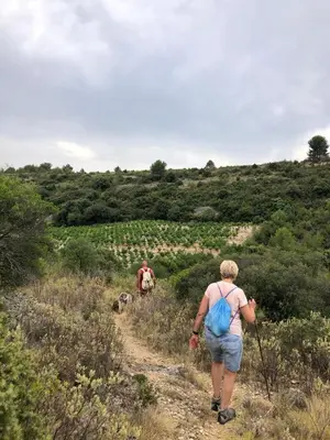 a woman walking down a dirt trail at Tiny House Belleraze in Saint-Jean-de-Minervois