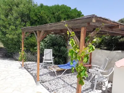 a wooden gazebo with chairs and avisor at Tiny House Belleraze in Saint-Jean-de-Minervois