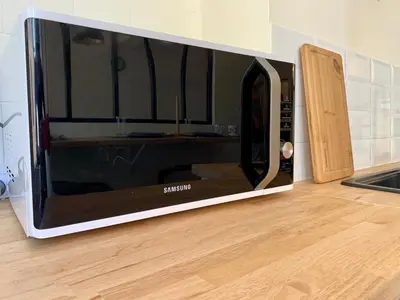 a microwave oven sitting on top of a kitchen floor at Appartements Voltaire - Carcassonne Centre in Carcassonne
