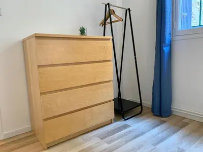 a chest of drawers in a room with a window at Appartements Voltaire - Carcassonne Centre in Carcassonne
