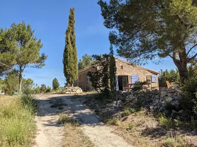 a bedroom with a bed in a stone wall at Bergerie éco-gîte Serre Rouge in Durban-Corbières