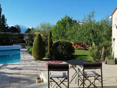 a patio with a table and chairs and a pool at Chambre d'hotes CHEVREFEUILLE in Molitg les Bains