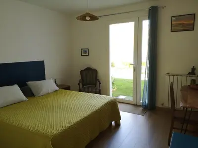 a bedroom with a bed and a sliding glass door at Chambre d'hotes CHEVREFEUILLE in Molitg les Bains