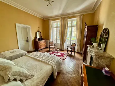 a bedroom with two beds and a fireplace at La Maison d'hôtes du Chapelier in Espéraza