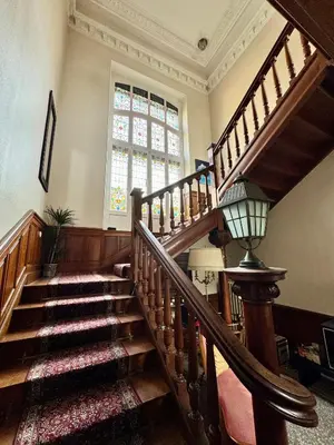 a staircase in a building with a large window and a window at La Maison d'hôtes du Chapelier in Espéraza
