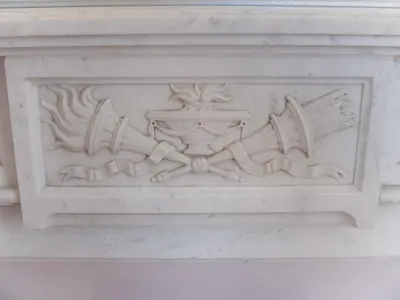 a carving on the side of a white building at La Maison d'hôtes du Chapelier in Espéraza