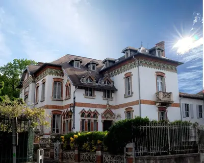 a large white house with a fence in front of it at La Maison d'hôtes du Chapelier in Espéraza