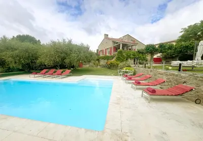 a swimming pool with lounge chairs and a house at Les Oliviers in Cesseras