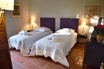 a bedroom with two beds with white sheets and towels at Les Oliviers in Cesseras