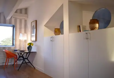 a dining room with white cabinets and a table at Les Oliviers in Cesseras