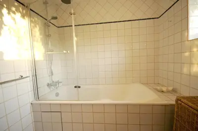 a bath tub in a tiled bathroom with a shower at Les Oliviers in Cesseras