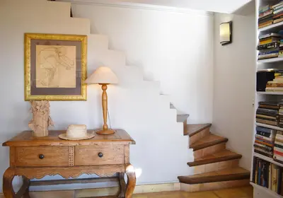 a stairway with a lamp on a dresser in a room at Les Oliviers in Cesseras