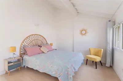 a white bedroom with a bed and a chair at Central Narbonne with rooftop terrace in Narbonne