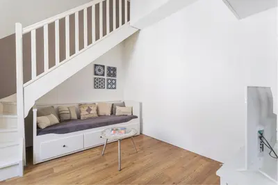 a room with a bed under the stairs at Central Narbonne with rooftop terrace in Narbonne