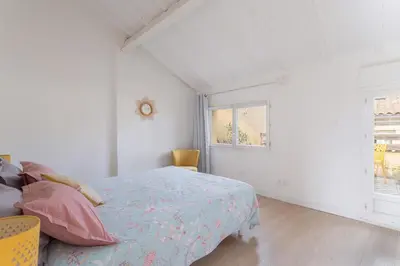 a white bedroom with a bed and a window at Central Narbonne with rooftop terrace in Narbonne