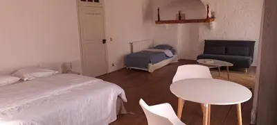 a bedroom with a bed and a couch and a table and chairs at les galets de l agly, 6 ch, 12 couchages Semaine ou WE famille amis copains in Le Vivier