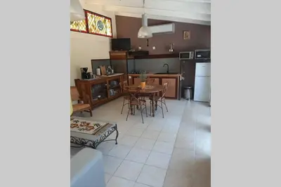 a kitchen and living room with a table and chairs at Loft atelier dans ancien domaine viticole in Moux